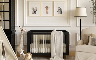 a baby nursery with white linen and a black crib