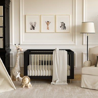 a baby nursery with white linen and a black crib